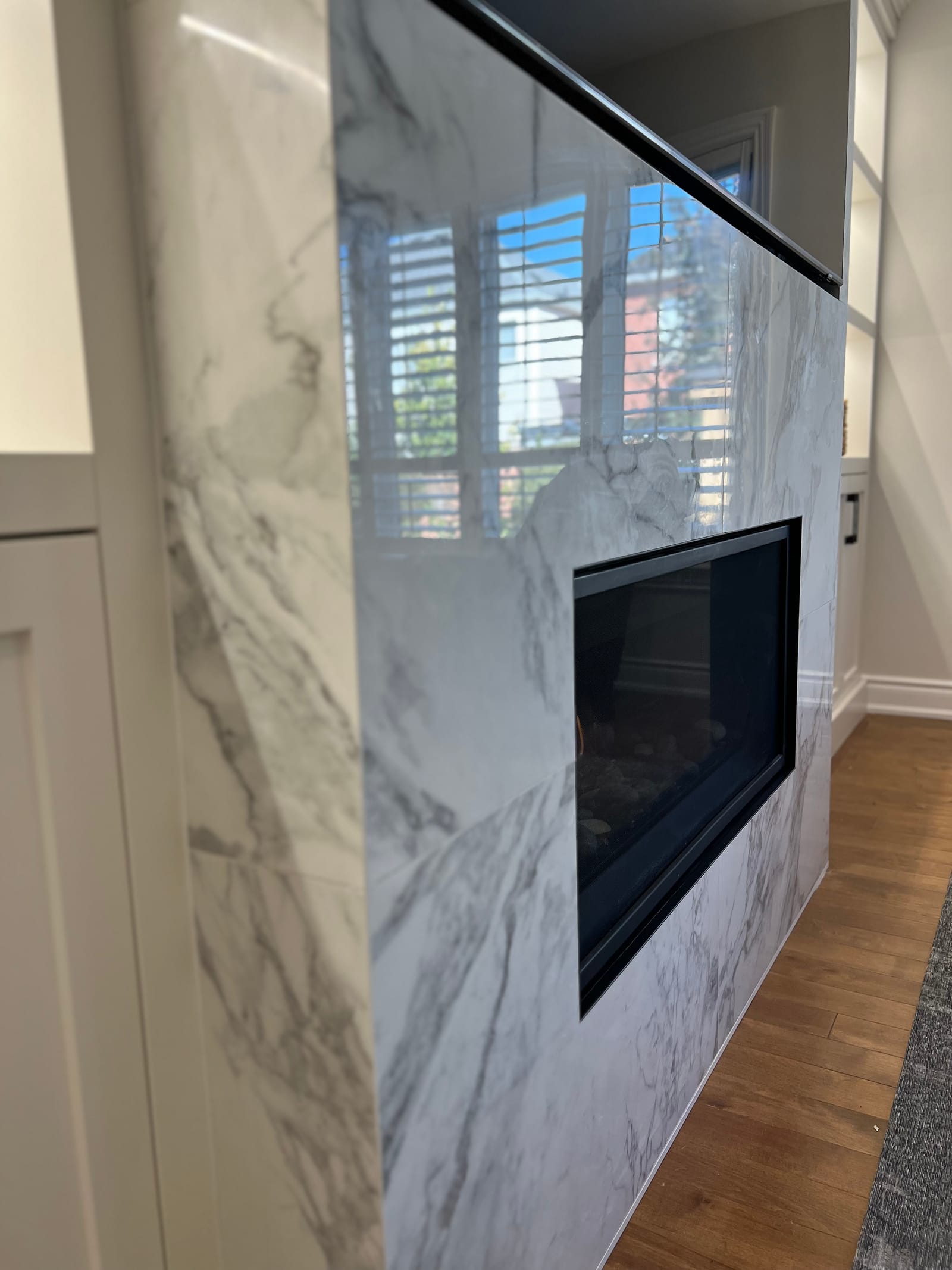 Side view of the fireplace column wrapped in marble-look slab